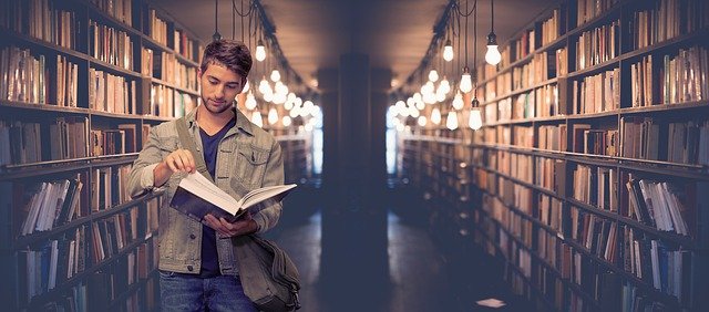 estudiante en una biblioteca leyendo un libro